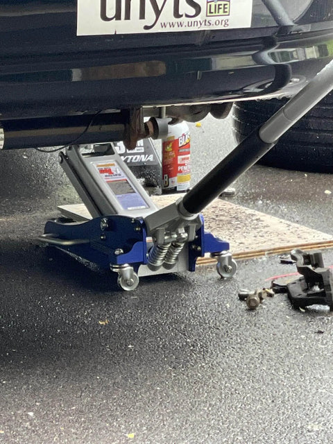 ✝️ 3000 Lb Aluminum Racing Car Auto Floor Jack Low Profile Rapid Pump Lift in use under vehicle with tools and lubricant nearby