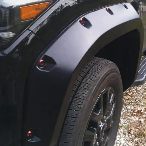 Widebody flare installed with 24 Piece M6 18mm Anodized Aluminum Tapered Washer Kit on a vehicle's front wheel arch