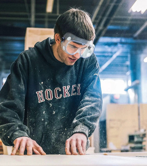 Man wearing Two Pack Anti Fog Safety Goggles With Adjustable Fit And Lightweight Lenses while working in a woodshop.
