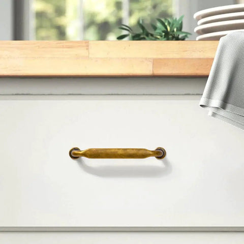 Six Pack Antique Brass Cabinet Pulls With 3 3/4 Inch Center To Center installed on white drawer in kitchen setting