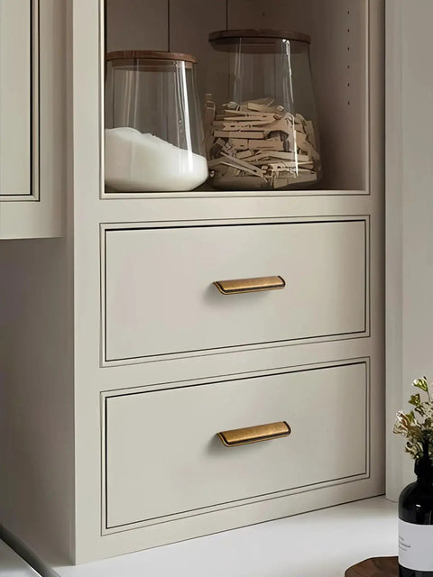 Five Pack 5 Inch Antique Brass Cabinet Cup Pulls For Kitchen And Bath installed on white drawers, 128mm length.
