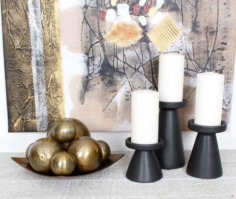 2.75 inch Decorative Balls, 6 Pieces, in a brass finish in a bowl next to black candle holders, modern home decor setup