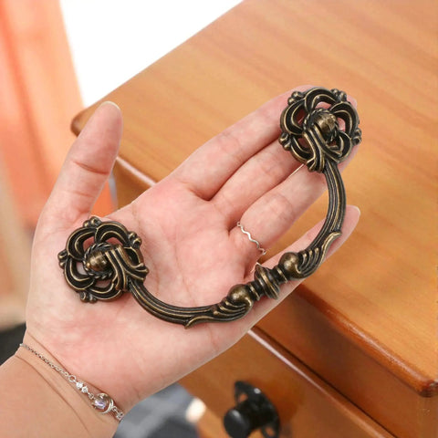 4-Pack Antique Brass Drawer Pulls 4.5 Inch Center-to-Center Drop Bail Dresser Handles Vintage Style Bronze Look Hardware shown in hand