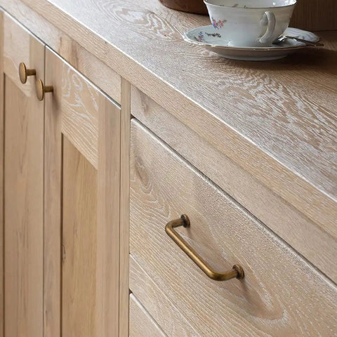 Six Pack Antique Brass Dresser Drawer Pulls Three And Three Quarters Inch Center To Center installed on wooden cabinet