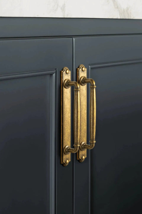 Antique Brass Drawer Pulls With Backplate Center To Center Five Point Zero Four Inches Zinc Alloy Cabinet Hardware installed on cabinet.