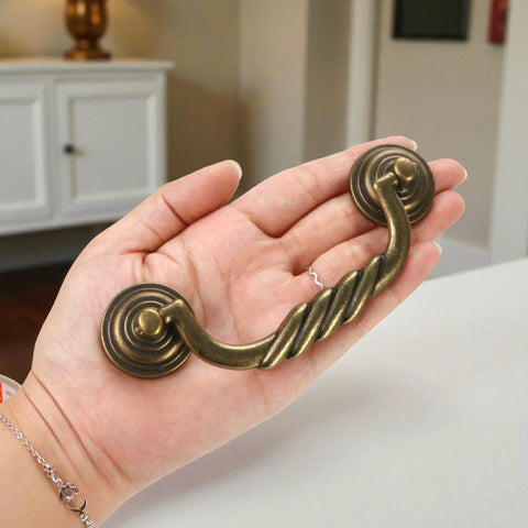 Hand holding antique bronze drawer pull, 4.5 Inch Center To Center Antique Bronze Drawer Pulls Pack Of 4 Bail Drop Swing Handles