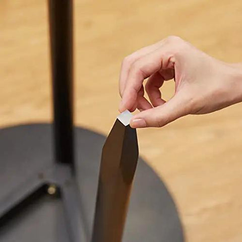 Close-up of a hand applying a clear adhesive bumper pad to a metal surface from the Clear Self Adhesive Cabinet Door Bumpers Set 300 Piece For Drawers And Cupboards Rubber Stoppers Surface Protection And Noise Reduction Multiple Shapes For Easy Install Quiet Closures And Dampened Cabinet Sounds.