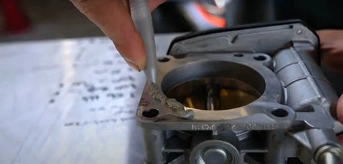 Applying Ultra Gray Rigid High Torque RTV Silicone Gasket Maker to engine component for valve covers and oil pans sealant.