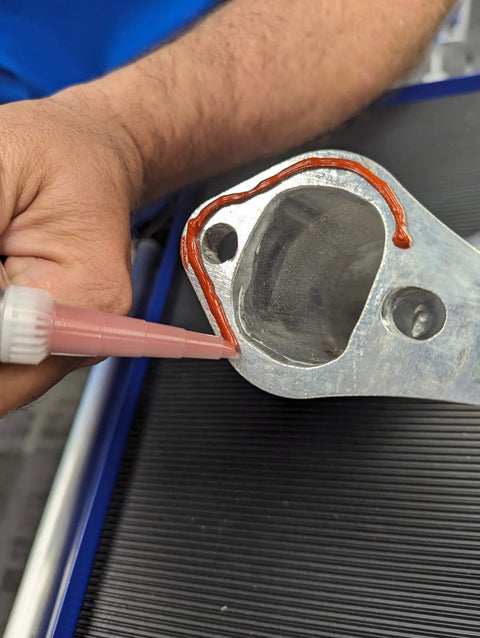 High-Temp Red RTV Silicone Gasket Maker 11 Oz Formed-In-Place Sealant applied on engine component edge