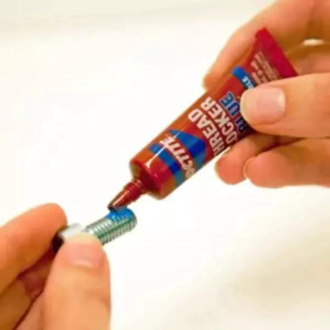 Applying Removable Thread Locker Blue 242 to bolt for medium strength fastening and corrosion prevention, ideal for small motors and mowers.