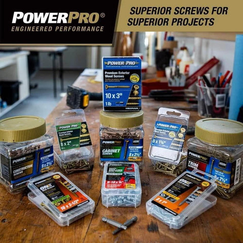 Assorted sizes of PowerPro premium exterior wood screws displayed on a workbench in a workshop.