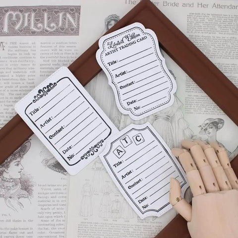 ATC Cards Die Set For Scrapbooking And DIY Card Making displayed on a vintage magazine, showing artist trading card designs