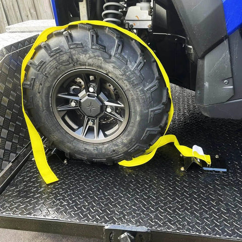 Heavy Duty Wheel Chock Tie Down Kit With 4,500 Lb Break Strength for ATVs UTVs Lawn Mowers And Trailers installed on a trailer