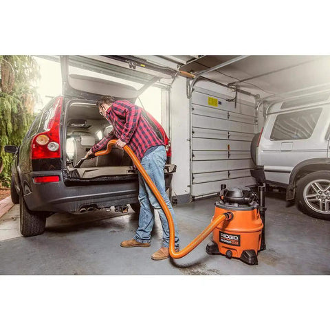 Person using 7 piece auto detailing hose kit with 1 1/4 inch hoses for cleaning car trunk in garage