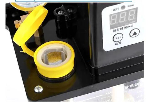 Close-up of 110V Auto Lube Pump With Digital Control and Dual Displays Plus Pressure Gauge, showing open reservoir and control panel.