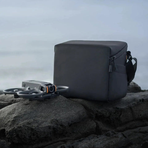 Premium Sling Bag For Avata 2 FPV Drone With Multiple Internal Compartments beside Avata 2 drone on rocky surface