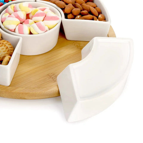 Divided Serving Dish Lazy Susan With 360 Degree Rotating Porcelain Tray on bamboo base, showing compartments with snacks and candy.