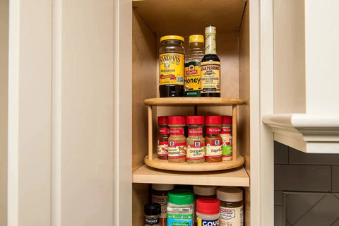 Eco Friendly Bamboo Wood Two Tier Turntable Ten Inch Diameter Kitchen Lazy Susan storing spices and condiments in a cabinet.