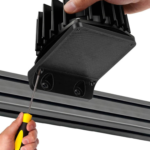 Installing Bass Shaker Mount For BST-1 Fits 100x100 Bass Vibrator on a metal rail with a screwdriver, highlighting reinforced design.