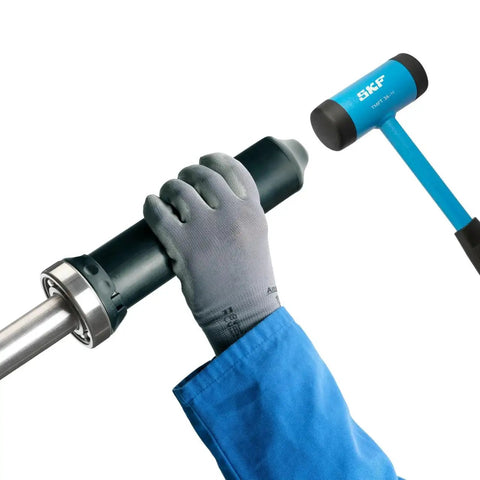 TMFT 36 Bearing Fitting Tool Kit For Mounting Bearings With Bore Diameters From 10 To 55 Mm Includes 36 Impact Rings 3 Impact Sleeves And Dead Blow Hammer In Durable Carry Case Ideal For Workshop Use And Industrial Maintenance Applications being used with gloved hands and hammer.