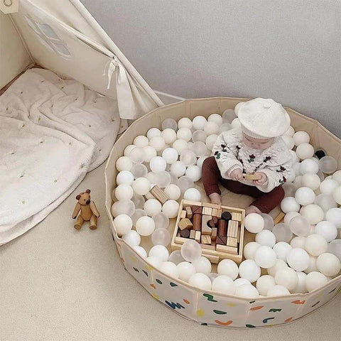Child playing in ball pit with 100 Ball Pit Balls Phthalate Free BPA Free Crush Proof Plastic - Beige Colors in play tent.