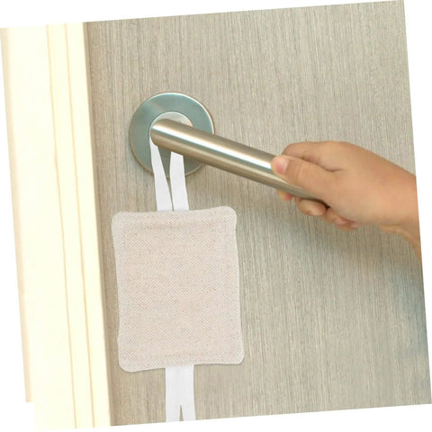 A hand holding a door handle with a beige no drill door silencer installed, showing how it cushions slams and protects fingers.