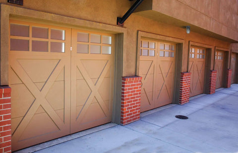 Row of brown garage doors on brick and stucco building exterior