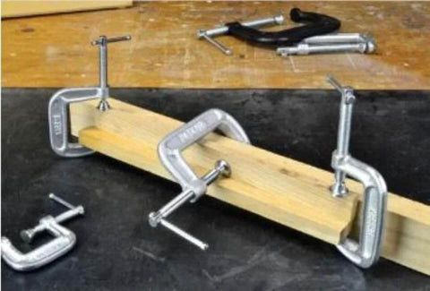 Bessey 4 Inch Drop Forged C Clamp with Swivel Pad clamping wood, showing galvanized finish and cold drawn steel spindle.