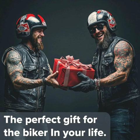 Two motorcyclists in leather vests exchanging a wrapped gift, wearing helmets, smiling, with the text 'The perfect gift for the biker in your life.'
