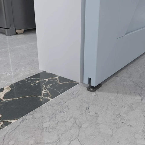 Black aluminum floor guide for sliding barn doors and bypass systems installed on marble flooring