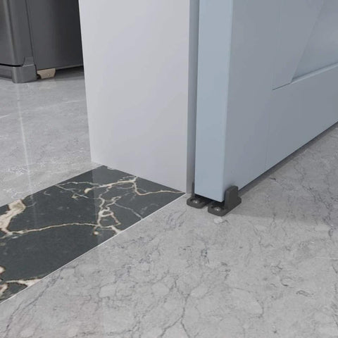 Black aluminum floor guide for sliding barn doors and bypass systems in a modern interior setting
