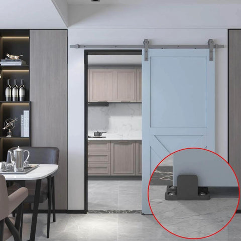Black aluminum floor guide for sliding barn doors and bypass systems, anodized finish, installed on grey floor with 1/8 inch arm.