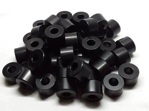Pile of black anodized aluminum spacers with 3/4 inch outer diameter and 3/8 inch bore, unthreaded for precise mounting.