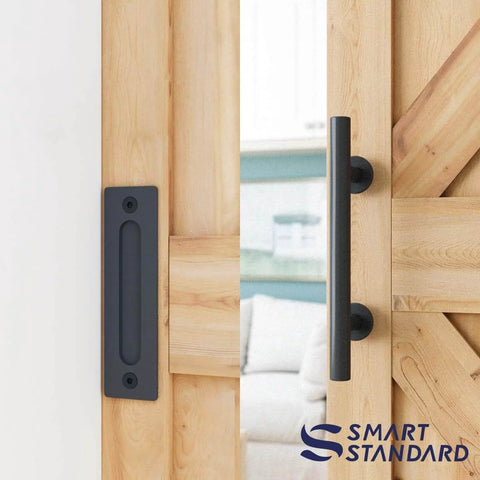 Close-up of 6.8 ft heavy duty sliding barn door hardware kit in black with pull handle, installed on wooden door panel.