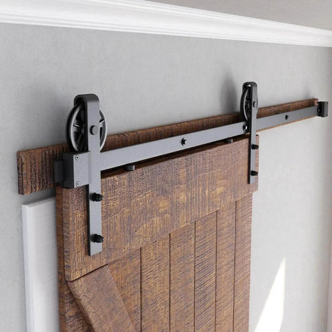 6ft Heavy Duty Sliding Barn Door Hardware Kit, Black shown installed on wood door with big industrial wheel hangers for 36" panels