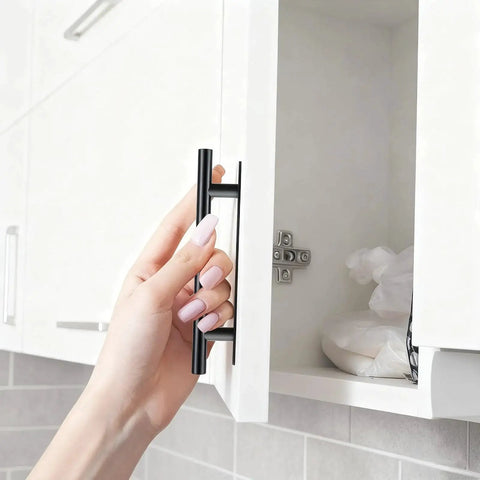 Hand installing black ABS plastic push-pull cabinet handle on a white door with no drill adhesive from 30 Pack Self Stick Push Pull Cabinet Handles.
