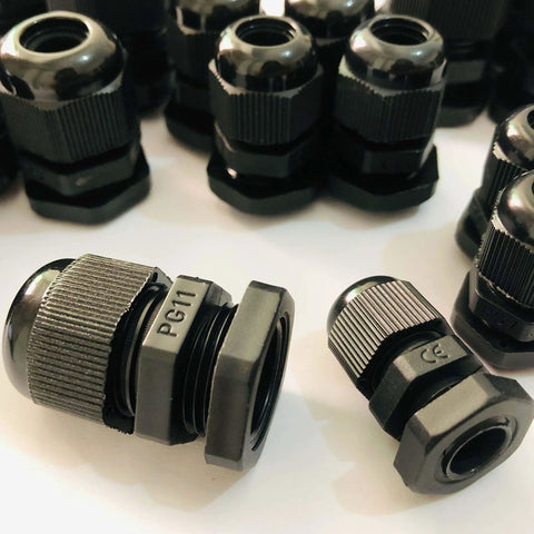 Assorted black cable glands labeled PG11 for secure wire connections on machinery or appliances