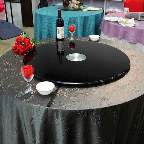Heavy Duty Black Glass Lazy Susan Turntable set on a table with wine and glasses, ideal for family dinners and elegant presentation.