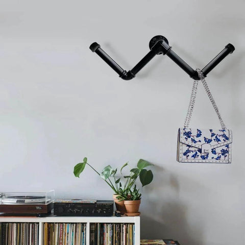 Wall-mounted 6 Pack 3 Quarter Inch Black Metal Pipe 36 Inch Pre Cut Industrial Steel Set for vintage DIY industrial shelving, holding a bag.
