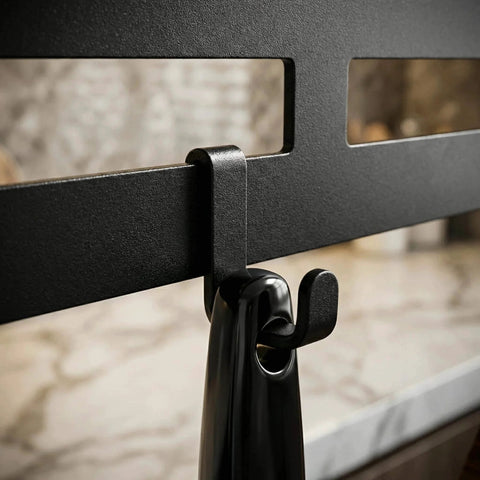 Close-up of wall mount utensil rack showing metal hook detail and installation on marble countertop.