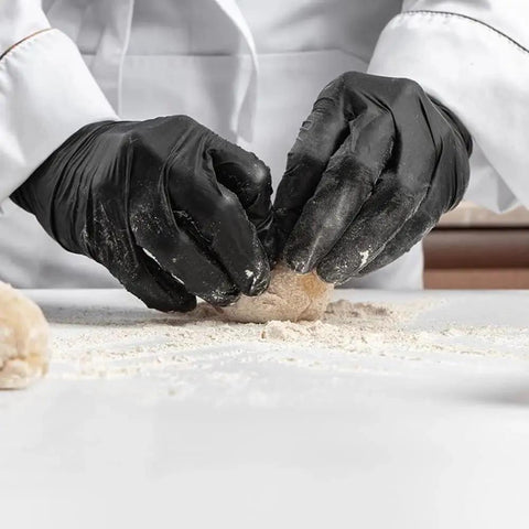 Chef wearing Black Nitrile Disposable Gloves 5 Mil Latex Free Industrial Food Safe X Large while preparing dough