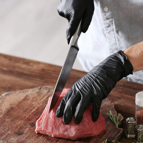 Chef wearing Black Vinyl Disposable Exam Gloves 4 Mil Latex Free Powder Free Medical 1000 while slicing meat