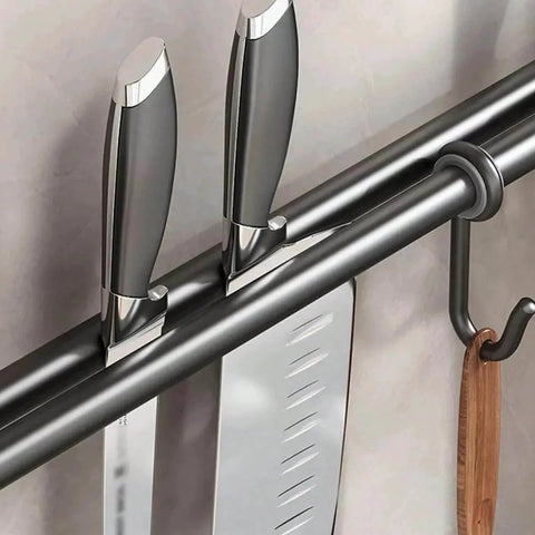 Close-up of Modern Kitchen Utensil Rack, Black Wall-Mounted Hanging Rod with 6 Movable Hooks holding knives and a wooden utensil.