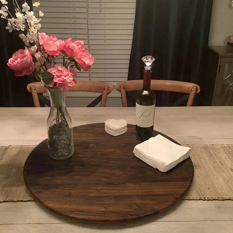 24 Inch Black Walnut Wood Lazy Susan Round Turntable for tabletop use, featuring a vase with flowers, wine bottle, and coasters.