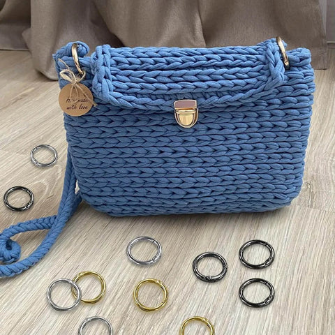 24 Pack Spring O Rings With Trigger Snap Buckles Keychain Rings For Bags And Purses 1 Inch Alloy Rings in various colors around a blue crochet bag.