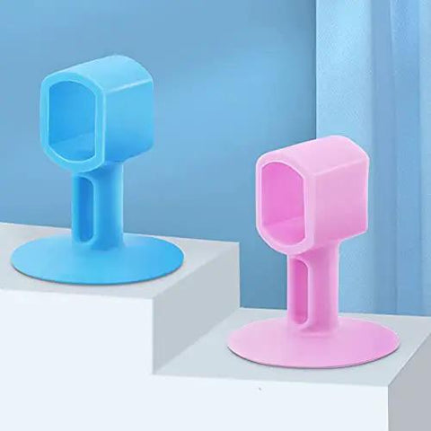 Two colorful silicone door handle bumpers in blue and pink on a shelf, designed to absorb impact and noise, protecting walls from scuffs.