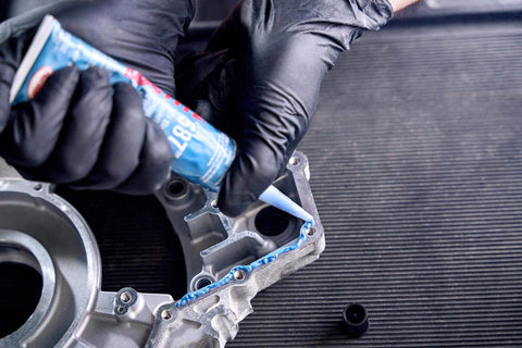 Person applying Auto Grade RTV Silicone Gasket Maker Blue 587 Pro Grade High Temp Oil Resistant Sensor Safe Non Corrosive Flexible Sealant