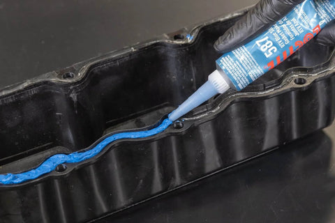 Auto Grade RTV Silicone Gasket Maker Blue 587 Pro Grade High Temp Oil Resistant Sensor Safe Sealant being applied to engine gasket