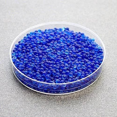 Clear dish of Blue Indicating Silica Gel Beads 3 To 5 Mm Desiccants Reusable Moisture Absorbers For Storage And Electronics on gray surface