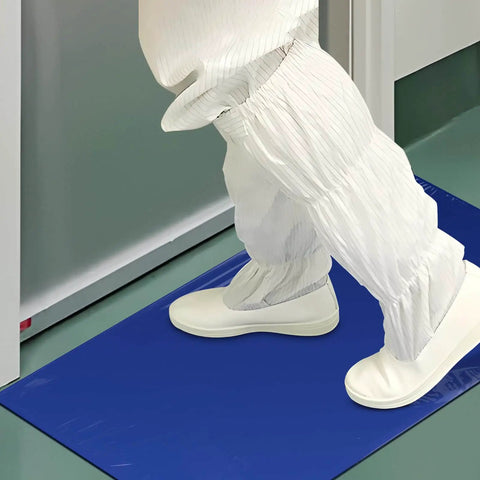 Person in lab attire stepping on blue sticky mat in cleanroom. Heavy Duty Sticky Mat Tacky Adhesive Pads 300 Sheets Bulk Pack